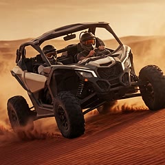 Can-Am Maverick X3 dune buggy kicking up sand on a Dubai dune